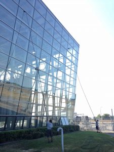 Professionals cleaning windows on commercial building